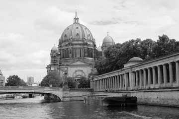Fototapeta na wymiar Der Berliner Dom mit der Spree und der Museumsinsel bei bewölktem Himmel in der Hauptstadt Berlin, fotografiert in klassischem Schwarzweiß
