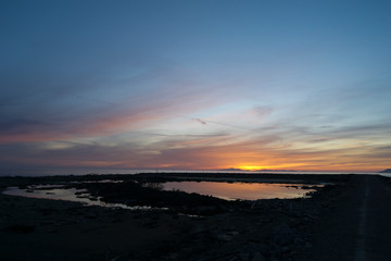 Italy, Tuscany, Grosseto, Maremma, Marina di Alberese, Natural Park of Maremma, also called Uccellina, sunset on the mouth of the river Ombrone; the sun sets behind the island of Elba