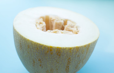 half of a juicy, ripe melon on a light blue background. Summer, vitamins, healthy sweets, weight...