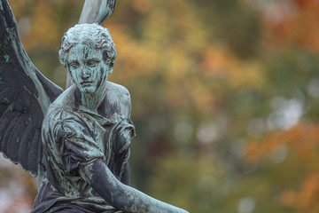 Statue of ancient beautiful winged angel in downtown park of Potsdam in beginning of Autumn at...