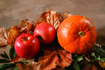 Naklejka na ściany i meble Autumn harvest. Pumpkin, red apples and autumn leaves. Autumn still-life.