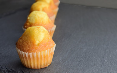 
Close up. Homemade mini muffins on slate table, space for text