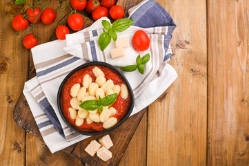 Homemade Italian Gnocchi with Red Sauce, Cheese with basil, olive oil . Close up. Home cooking. Traditional Italian cuisine from Rome and Sardinia. Above