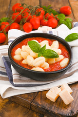 Homemade Italian Gnocchi with Red Sauce, Cheese with basil, olive oil . Close up. Home cooking. Traditional Italian cuisine from Rome and Sardinia. Vegetarian food