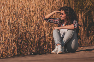 Obraz premium Female hiker sitting at lake docks