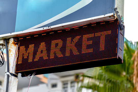 Retro Word Market Written With Led Sigh On The Road. Real Candid Photo Of The Word. Market Concept.