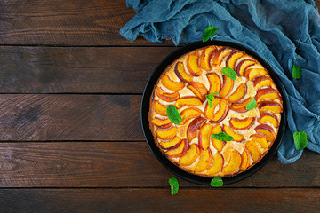 Delicious homemade peach pie on wooden background. Top view