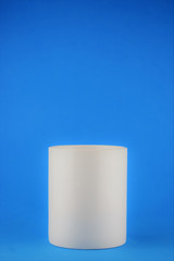 Close-up white porcelain cup, blue background and space for text