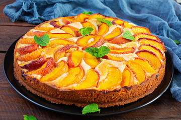 Delicious homemade peach pie on wooden background