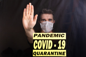 Man in respiratory mask showing stop gesture. Guy show gesture no. Stop coronavirus or covid-19 and the pandemic. Stay home. Quarantine concept.