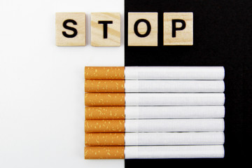 Close-up of cigarettes and wooden blocks, showing the safe word on a white, black background. World no tobacco day in may. The concept to quit Smoking. Harm to health from Smoking. Flatly. Copyspace.