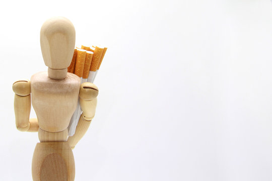 An illustration of a wooden mannequin heavily carrying an armful of cigarettes behind its back on a white background. World no tobacco day. The concept to quit Smoking. Harm to health. Copyspace