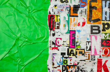 Torn and crumpled green glossy paper on abstract colorful collage of magazine paper pieces and clippings with letters and numbers background.