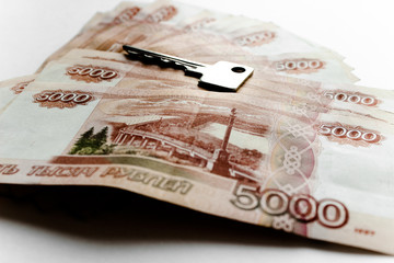 Metal keys on a horizontal background of a variety of banknotes of five thousand Russian rubles. Concept of buying an apartment, flat or house, mortgage, rental housing, housewarming, home expense