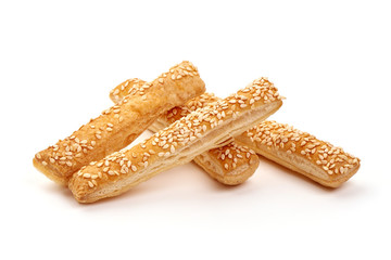 Puff pastry cookies with sesame seeds, isolated on white background.