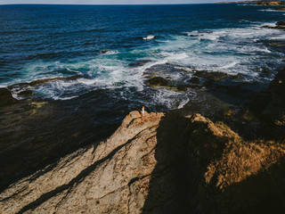 woman on ocean rocks