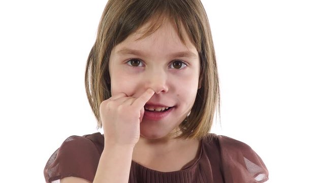 Blonde caucasian girl 6-7 years, nose picking using index finger.