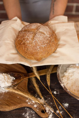 Fresh natural bread in the hands of a baker