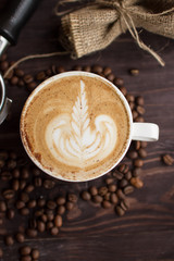 close-up frame. cup of coffee. latte art. coffee beans and accessories on a dark background