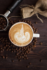 cup of coffee. latte art. coffee beans and accessories on dark background