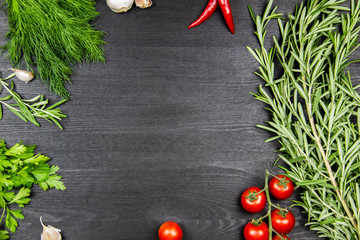 Composition with pepper, tomatoes, dill, parsley, garlic, rosemary in the dark wood background. Cooking food background with free space for text. Top view with copy space