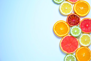 Close up image of juicy organic assorted sliced citrus fruits, visible core texture, bright paper textured background, copy space. Vitamin C loaded food concept. Top view, flat lay.