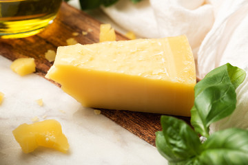 Parmesan cheese and fresh basil and olive oil. Ingredients for a pesto sauce. Italian food on marble cutting board