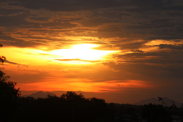 Beautiful sunset with exotic mountain and trees silhouette.
