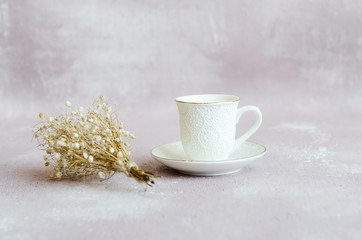 Obraz na płótnie Canvas White cup of tea or coffee on a pink background with dried flowers. Wallpaper, Cozy Vintage Concept. Copy space. 