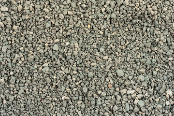 Gray small rocks ground texture. black small road stone background. gravel pebbles stone seamless texture. dark background of crushed granite gravel, close up. clumping clay