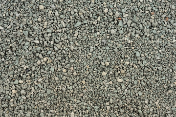 Gray small rocks ground texture. black small road stone background. gravel pebbles stone seamless texture. dark background of crushed granite gravel, close up. clumping clay