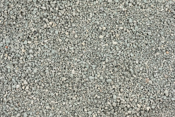 Gray small rocks ground texture. black small road stone background. gravel pebbles stone seamless texture. dark background of crushed granite gravel, close up. clumping clay