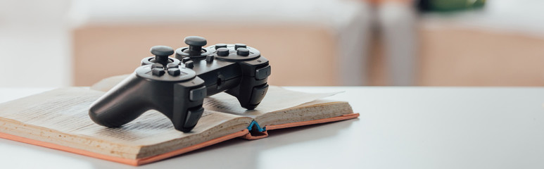website header of black joystick over open book on white table © LIGHTFIELD STUDIOS