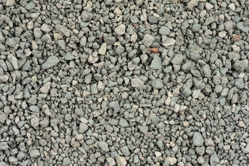 Gray small rocks ground texture. black small road stone background. gravel pebbles stone seamless texture. dark background of crushed granite gravel, close up. clumping clay