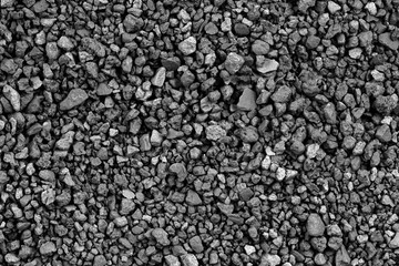 Gray small rocks ground texture. black small road stone background. gravel pebbles stone seamless texture. dark background of crushed granite gravel, close up. clumping clay