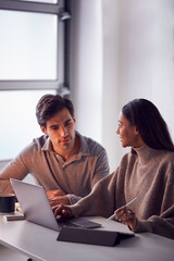 Businesswoman Working On Digital Tablet With Stylus At Desk Collaborating With Male Colleague