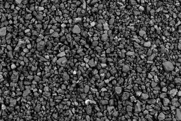 Gray small rocks ground texture. black small road stone background. gravel pebbles stone seamless texture. dark background of crushed granite gravel, close up. clumping clay