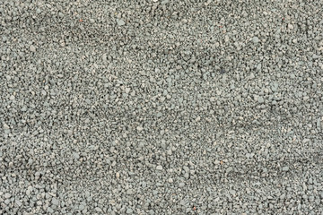 Gray small rocks ground texture. black small road stone background. gravel pebbles stone seamless texture. dark background of crushed granite gravel, close up. clumping clay