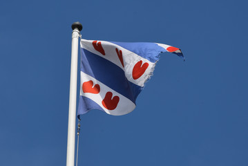 the flag of friesland flaps on the Afsluitdijk