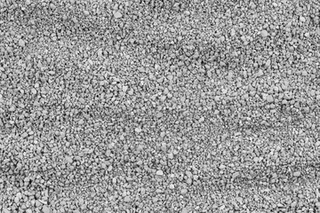 Gray small rocks ground texture. black small road stone background. gravel pebbles stone seamless texture. dark background of crushed granite gravel, close up. clumping clay