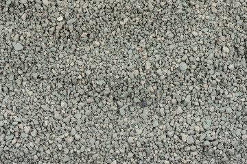 Gray small rocks ground texture. black small road stone background. gravel pebbles stone seamless texture. dark background of crushed granite gravel, close up. clumping clay