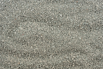 Gray small rocks ground texture. black small road stone background. gravel pebbles stone seamless texture. dark background of crushed granite gravel, close up. clumping clay
