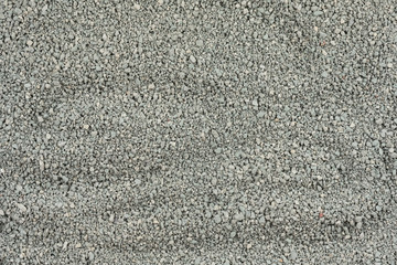 Gray small rocks ground texture. black small road stone background. gravel pebbles stone seamless texture. dark background of crushed granite gravel, close up. clumping clay