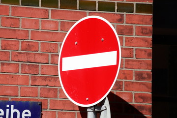 Verkehrsschild Einbahnstraße, Verbot der einfahrt vor einer rötlichen Backsteinmauer