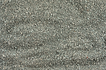 Gray small rocks ground texture. black small road stone background. gravel pebbles stone seamless texture. dark background of crushed granite gravel, close up. clumping clay