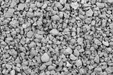 Gray small rocks ground texture. black small road stone background. gravel pebbles stone seamless texture. dark background of crushed granite gravel, close up. clumping clay
