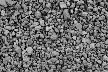 Gray small rocks ground texture. black small road stone background. gravel pebbles stone seamless texture. dark background of crushed granite gravel, close up. clumping clay