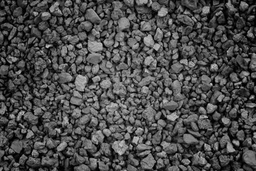 Gray small rocks ground texture. black small road stone background. gravel pebbles stone seamless texture. dark background of crushed granite gravel, close up. clumping clay