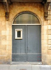 Fototapeta na wymiar Gray entrance door in a building in the historic centre of Bordeaux, Gironde, France