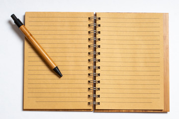 Top view of an open notebook with a pen or pencil on a white background. Flat lay, copy space. Business concept